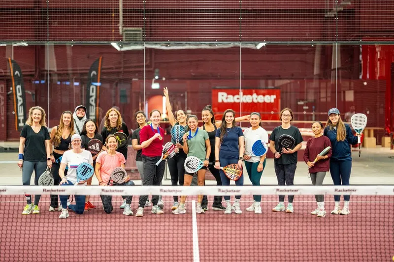 A team lined up on court under the Racketeer banner.